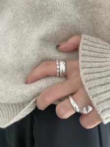 Close-up of stacked minimalist 925 sterling silver rings worn on a hand