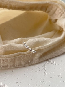 Macro shot of silver ring with oval patterns and small inlaid sparkling stones