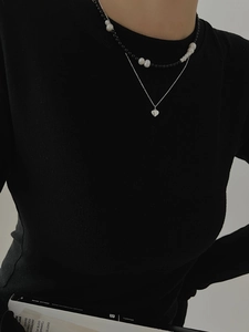 Detail of layered silver heart key pendant and black beaded pearl necklace set