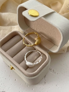 Detail view of gold and silver sterling silver rings with hammered texture in jewelry box