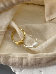 Detail of 925 sterling silver wavy rings with matte texture in gold and silver finish