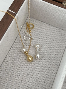 Detail of silver and gold necklaces with pearls, water drop pendants and OT clasps