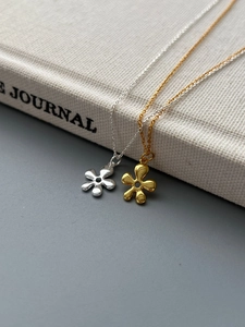 Detalle del collar de flor en plata S925 en acabados de color oro y plata