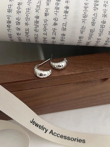 Vue détaillée des boucles d'oreilles croissant en argent S925 sur une surface en bois