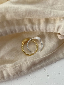 Macro shot of 925 sterling silver rings with lava texture on beige fabric pouch