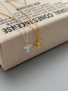 Detail of gold and silver heart-shaped key pendant necklaces on a gift box