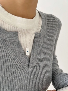 Detail of s925 silver necklace with rectangular pendant and blue gemstone on a sweater