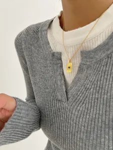 Detailed close-up of golden sun god pendant necklace with a blue gemstone on a model