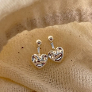 Boucles d'oreilles cœur souriant en argent 925 sur fond en tissu beige minimaliste
