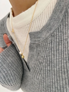 Close-up of S925 silver perfume bottle pendant necklace on a knit sweater surface