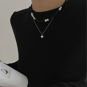 Minimalist double-layer necklace with heart pendant and mixed pearls on a model