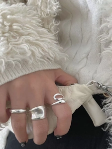 Detailed view of three minimalist S925 sterling silver geometric rings on a model