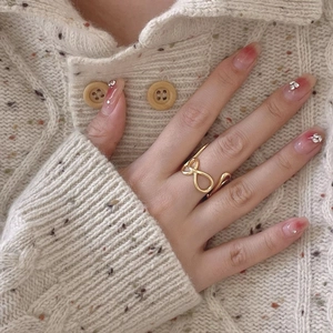 Minimalist gold S925 silver infinity ring with an adjustable open design on a knited background
