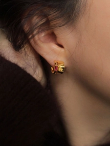 Close-up of 925 silver gold earring featuring a rectangular pink cubic zirconia stone