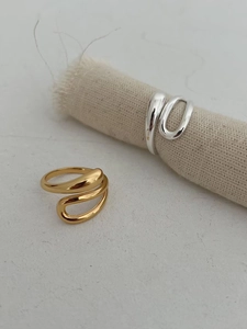 Macro detail of minimalist liquid metal rings in polished gold and silver finishes