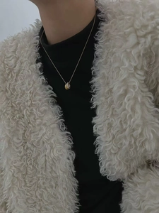 Detail of interlocking gold and silver brushed rings with micro-pave crystals on a thin chain
