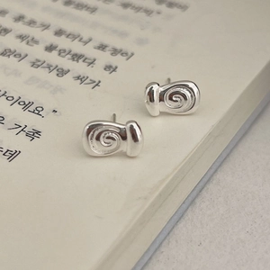 Minimalistische silberne Muschel-Ohrstecker auf einem offenen Buch für Damen