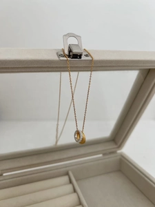 Detail of interlocking gold matte and silver pavé rings on a delicate gold chain necklace