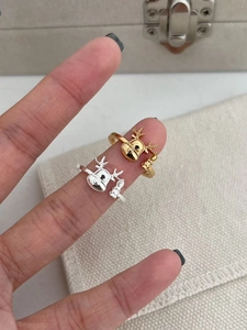 Close-up of gold and silver reindeer antler rings worn on fingers for Christmas gift