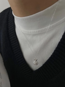 Dettaglio della collana con ciondolo portafortuna in argento 925 sulla clavicola