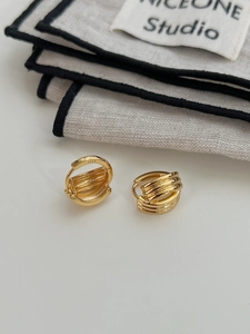 Détail du poinçon S925 sur les boucles d'oreilles géométriques dorées multicouches