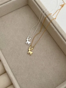 Gros plan de pendentifs rennes en or et argent sur un support de présentation bijoux