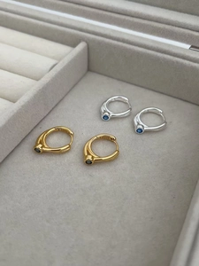 Detail of S925 sterling silver hoop earrings with blue zircon in gold and silver finish