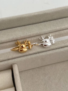 Detail of silver and gold reindeer rings with creative antler designs in a jewelry box