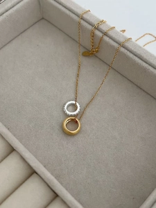 Macro shot of two-tone 925 silver pendant necklace with matte gold ring and sparkling crystals