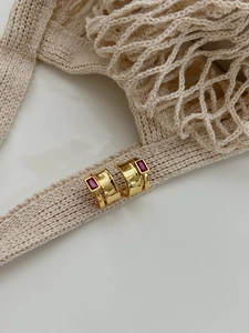 Detail of 925 silver gold C-shape hoop earrings with rectangular red cubic zirconia stone