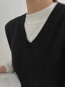Détail d'un collier en argent 925 avec pendentif clé et gravure LOVE porté par un mannequin