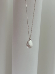 Detailed view of irregular teardrop pendant with brushed matte texture on S925 silver chain