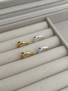 Macro detail of S925 sterling silver hoop earrings with blue zircon in a jewelry box