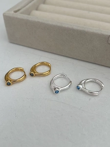 Detail of S925 sterling silver hoop earrings with blue zircon in gold and silver finishes