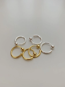 Close-up of S925 sterling silver and gold C-shaped earrings with bead ends