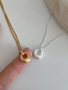 Vue détaillée des pendentifs cercles mats brossés en finitions or et argent