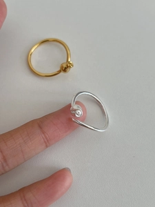 Detail view of 925 sterling silver and gold flower open rings on a white surface