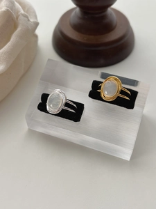 Detailed view of dual-layer sterling silver rings with oval white agate in gold and silver
