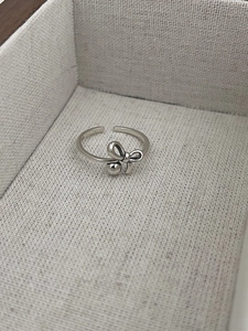 Gros plan d'une bague nœud en argent S925 avec anneau ajustable sur lin