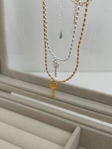 Détails des pendentifs clé cœur en or et argent gravés LOVE sur des chaînes fines