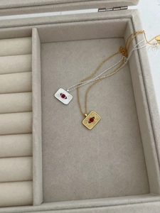 Detail of vintage 925 silver sunburst necklaces with red zircon in a velvet jewelry box