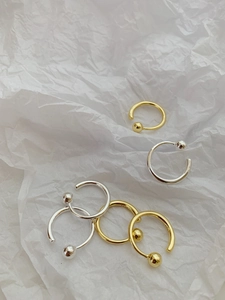 Detail of S925 sterling silver beaded open rings in gold and silver finish on white paper