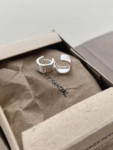 Detail of brushed silver crescent hoop earrings showing matte texture and polished interior