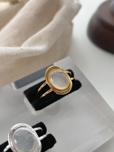 Detailed macro view of an oval white agate stone set on a golden double-layered ring band