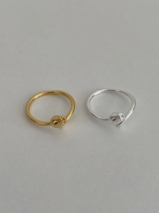 Flat lay view of 925 sterling silver knot rings in polished gold and silver finishes