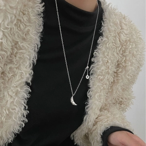 Silver crescent moon necklace for women on black sweater with beige wool jacket