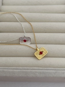Detailed close-up of gold and silver sun-motif necklaces with red central stones