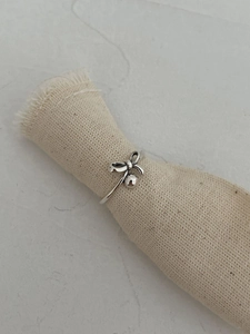 Gros plan détaillé d'une bague nœud en argent 925 avec une perle en métal poli