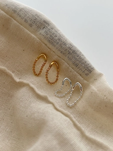 Détail des boucles d'oreilles S925 en forme de V en finitions or et argent
