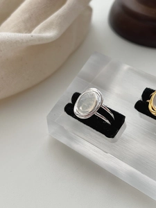 Close-up of S925 sterling silver ring with oval white agate stone on luxury display